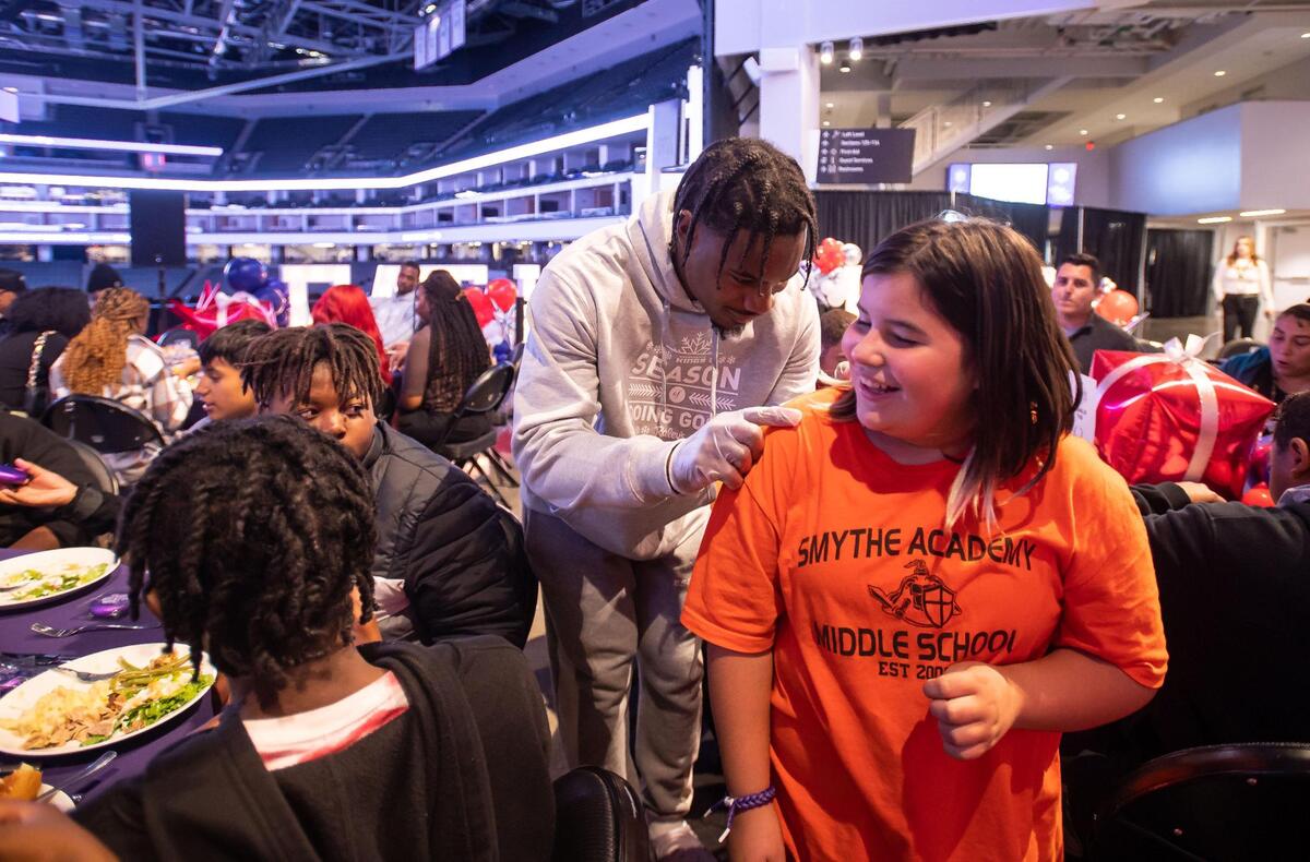 Sacramento Kings guard Davion Mitchell signs 12-year-old Paula Gomez’s shirt during the “Eat Like a King” event. The children at his table all asked for autographs and he obliged, signing everything from shoes to basketballs.