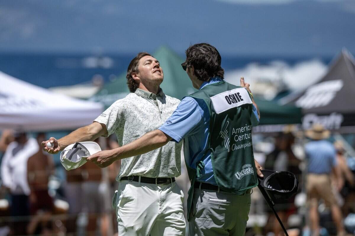 Former NFL player TJ Oshie is embraced by his caddie near the 17th hole during the American Century Championship at Edgewood Tahoe Golf Course in Stateline, Nev., on Friday, July 10, 2026.