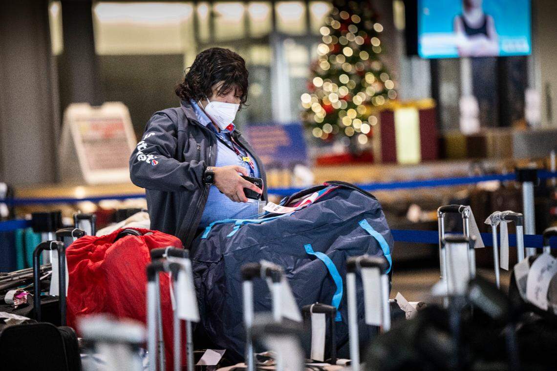 A Southwest employee checks bags at the Sacramento International Airport’s Terminal B on Thursday, Dec. 29, 2022. A large number of bags are still waiting to be picked up or delivered to their final destination. 