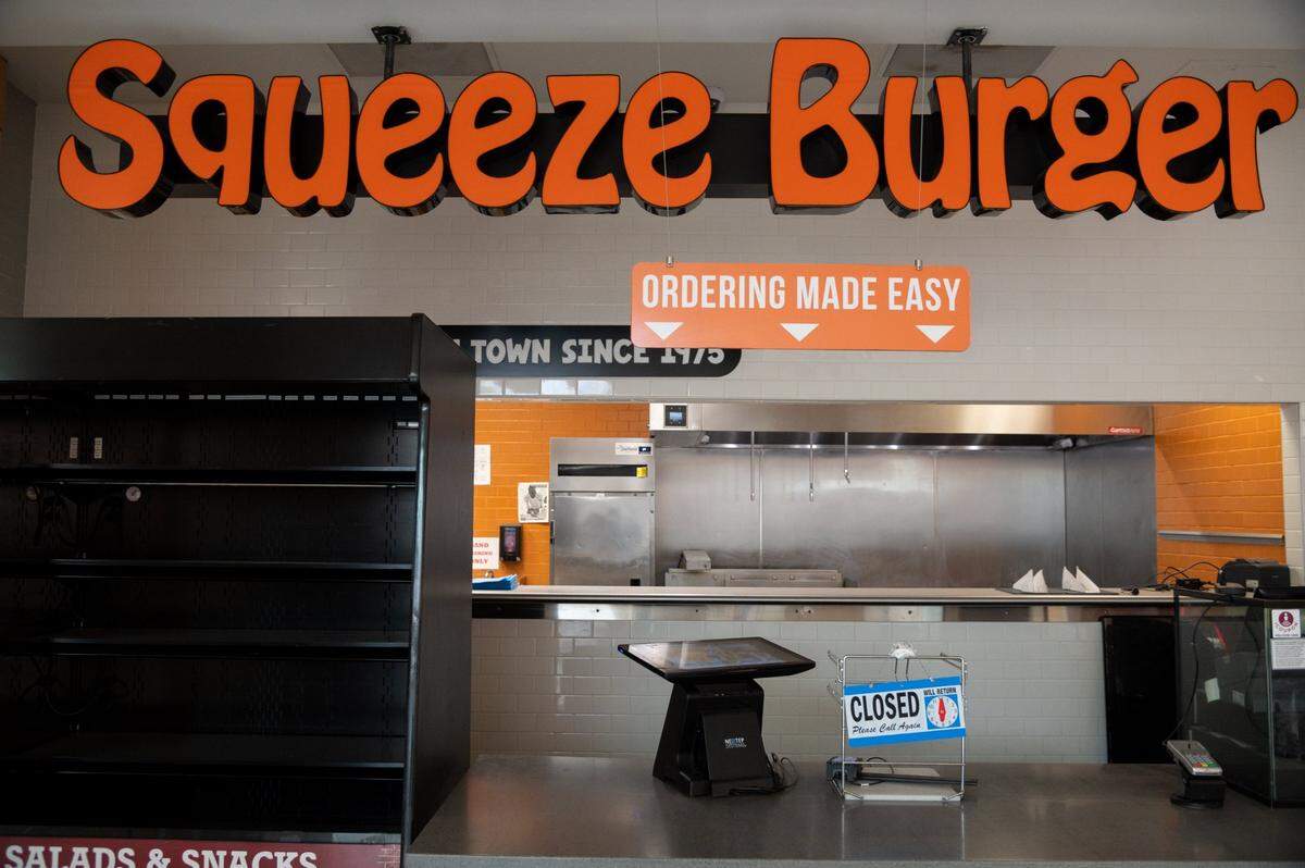A sign at the Squeeze Burger on Tuesday afternoon, Oct. 26, 2021, says that the restaurant in Terminal A at the Sacramento International Airport will reopen at 6 p.m. Many concessions have closed or are operating on reduced hours because of labor shortages.