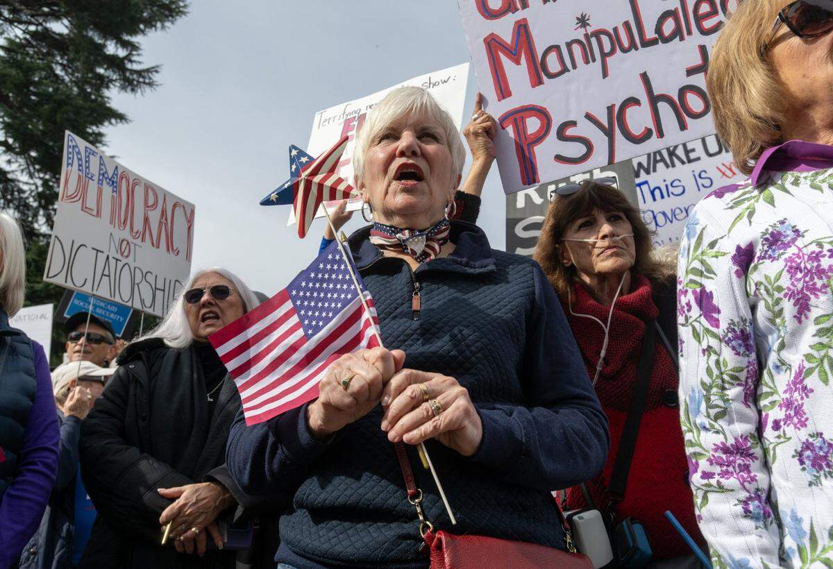 Sheila Inks participates in a President’s Day protest on Monday at the state Capitol against President Donald Trump and his administration that was part of a nationwide action organized by members of the grassroots organization 50501 Movement.