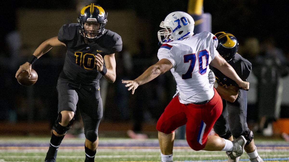 Oak Ridge quarterback Justin Lamson runs as Folsom’s Jake Melander attempts a sack Friday, Sept. 20, 2019, at Oak Ridge High School. Lamson, The Sacramento Bee's 2019 Player of the Year, now quarterbacks Montana State, which will host UC Davis.