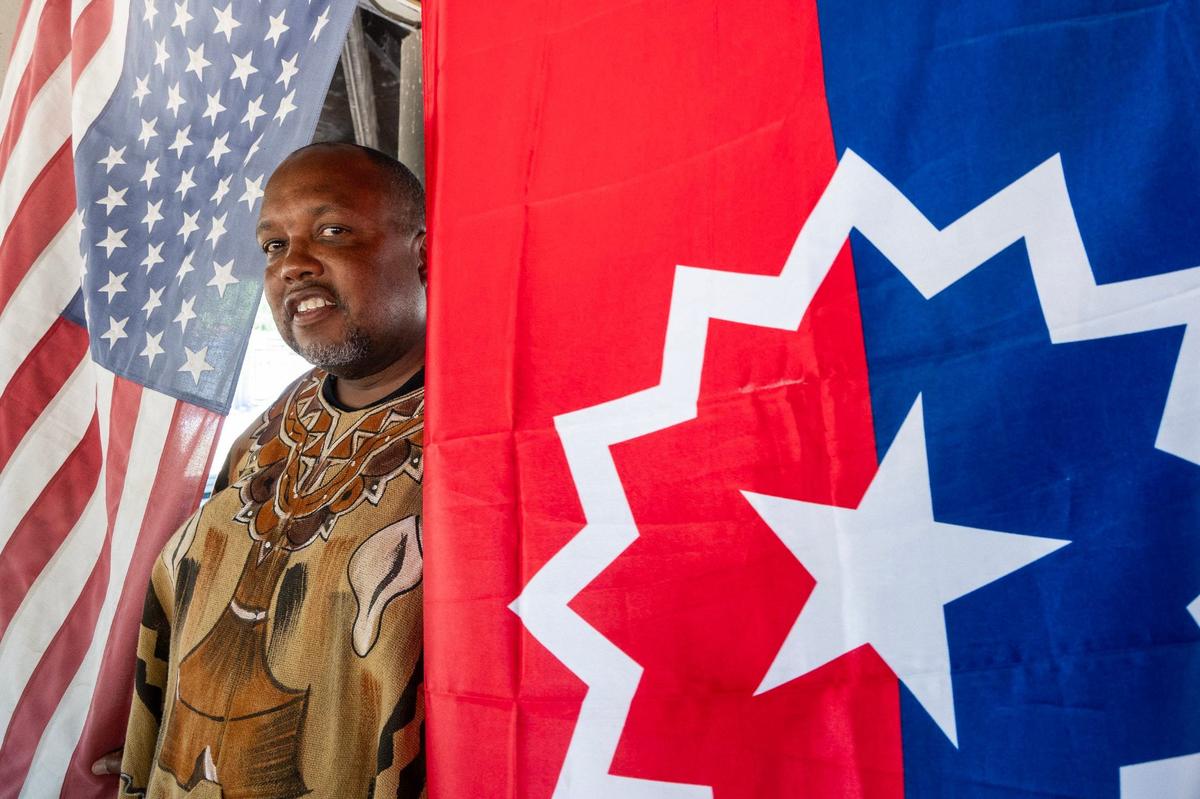 Michael Harris stands between the American and the Juneteenth flags in Folsom on Friday, June 7, 2024. Harris is part of a statewide movement, National Juneteenth Observance Foundation-California, to urge California cities to observe Juneteenth as an official public holiday.