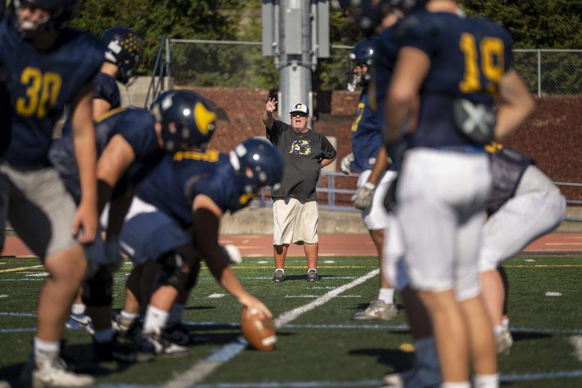 Head coach Casey Taylor shouts commands before a play during a football practice at Oak Ridge High School in El Dorado Hills on Aug. 5. 