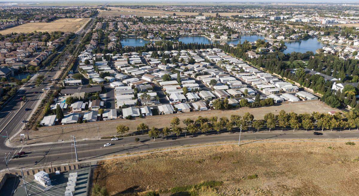 Vehicles drive past a long, slender parcel at the corner of El Centro Road and Arena Boulevard in North Natomas, south of the Stadium Club Estates mobile home park, on Thursday. The city-owned property was one of four recently identified in a Sacramento building permit application as a potential tiny home site for homeless residents age 55 and older.
