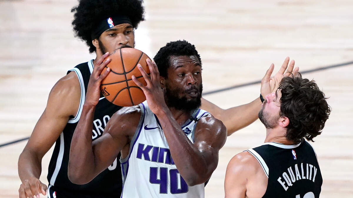 Sacramento Kings’ Harrison Barnes, center, drives against Brooklyn Nets’ Joe Harris, right, and Jarrett Allen, back, during the first half of an NBA basketball game Friday, Aug. 7, 2020 in Lake Buena Vista, Fla. (AP Photo/Ashley Landis, Pool)