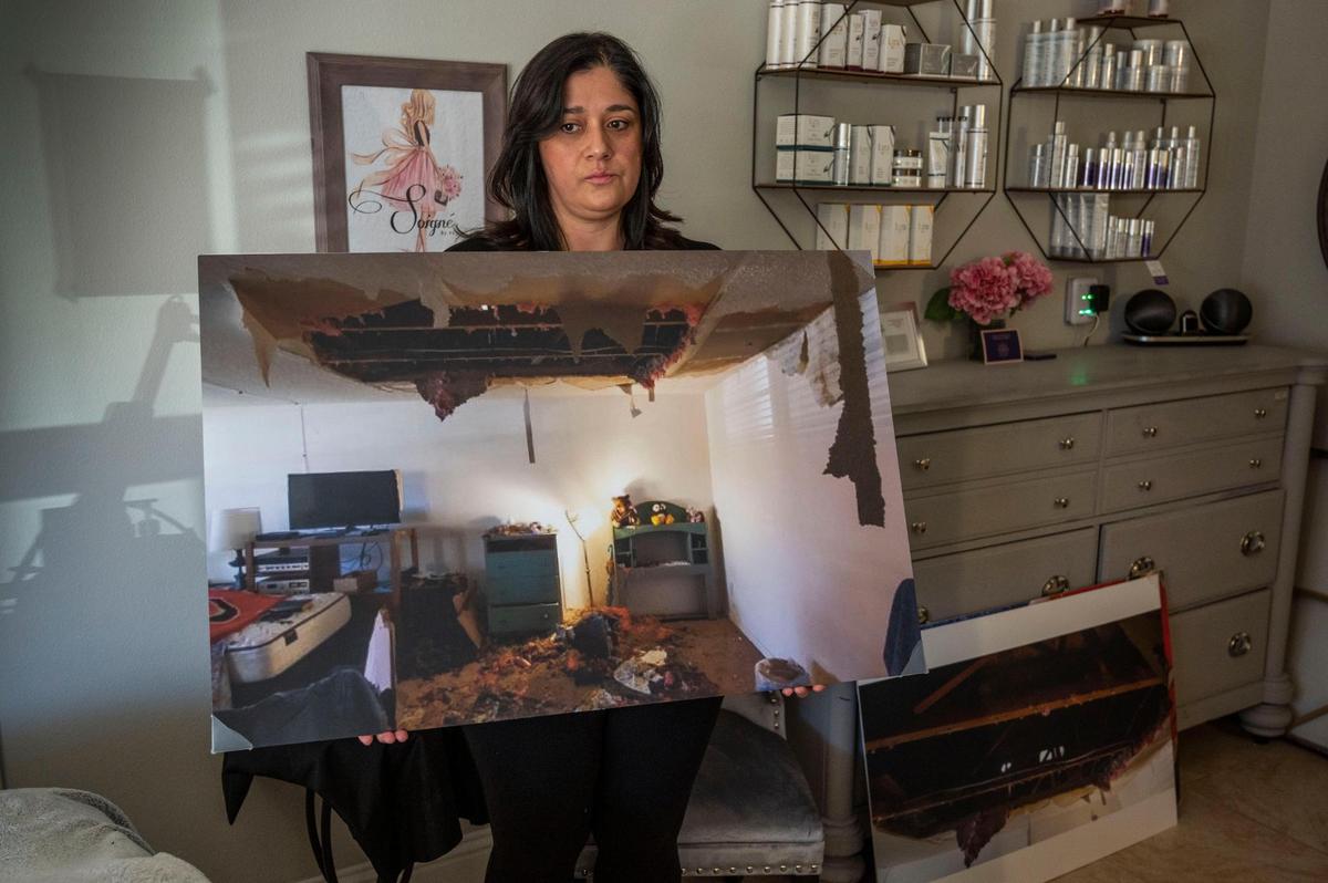 Danielle Fiddy holds a photo on Thursday, Jan. 19, 2022, of the room where her father, Ronald Villa, was found dead after the ceiling of his Citrus Heights senior home condo collapsed in October. She’s suing, alleging that apartment managers failed to repair the leaks above her father’s residence.