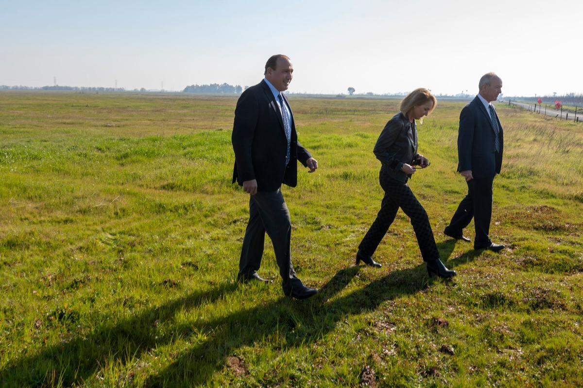 Kyriakos Tsakopoulos walks with University Development Foundation board members Julie Tell and Dave Siegel at the planned site of Hillsdale College on Thursday in Placer County. In November, the private college paid $5.8 million to acquire 1,100 acres of farmland owned by the foundation, a nonprofit established by Tsakopoulos and his father Angelo.