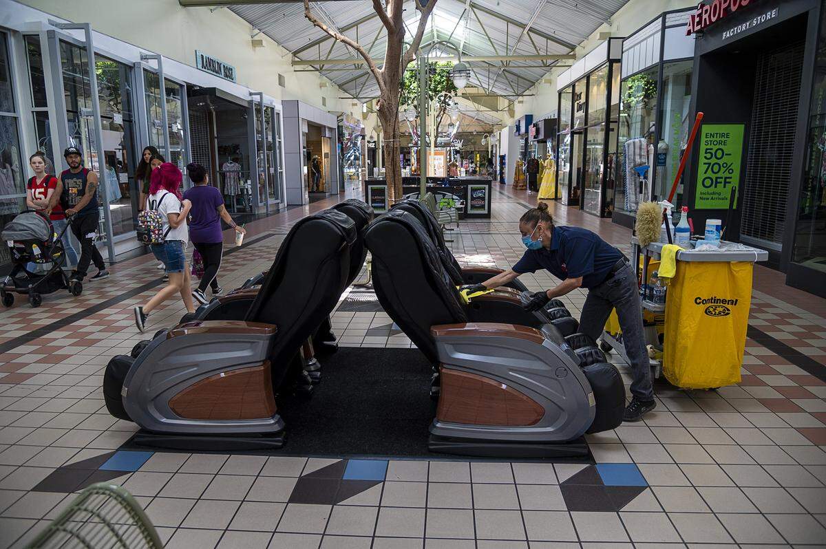 Janitor Linda Figueroa sanitizes massage chairs in the Yuba Sutter Mall on Wednesday, May 6, 2020 in Yuba City. She circles the mall constantly cleaning and disinfecting. It was the first day the mall was open after county health officials allowed retail stores to reopen in defiance of the state’s stay-at-home order to slow the spread of the coronavirus.