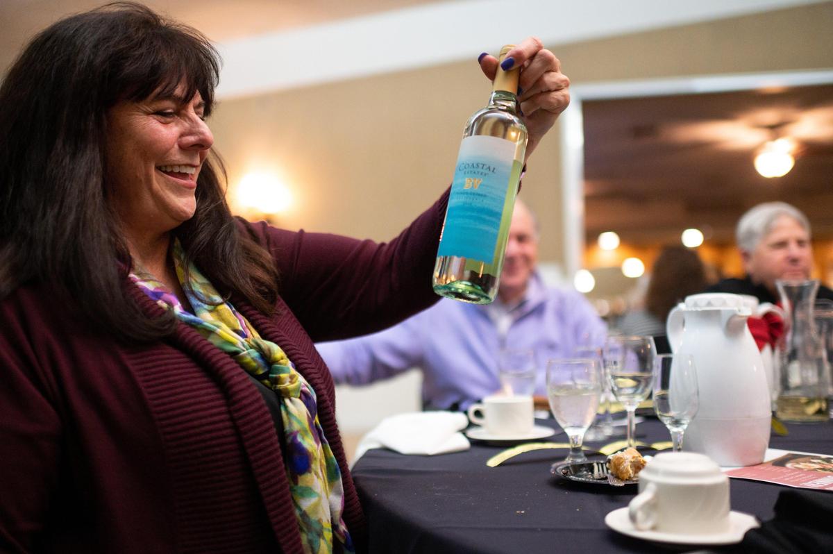 Debra Cattuzzo, co-president of the Dante Club Women’s Auxiliary, accepts a bottle of wine from a fellow diner during the monthly Tuesday Dinner on Feb. 4.