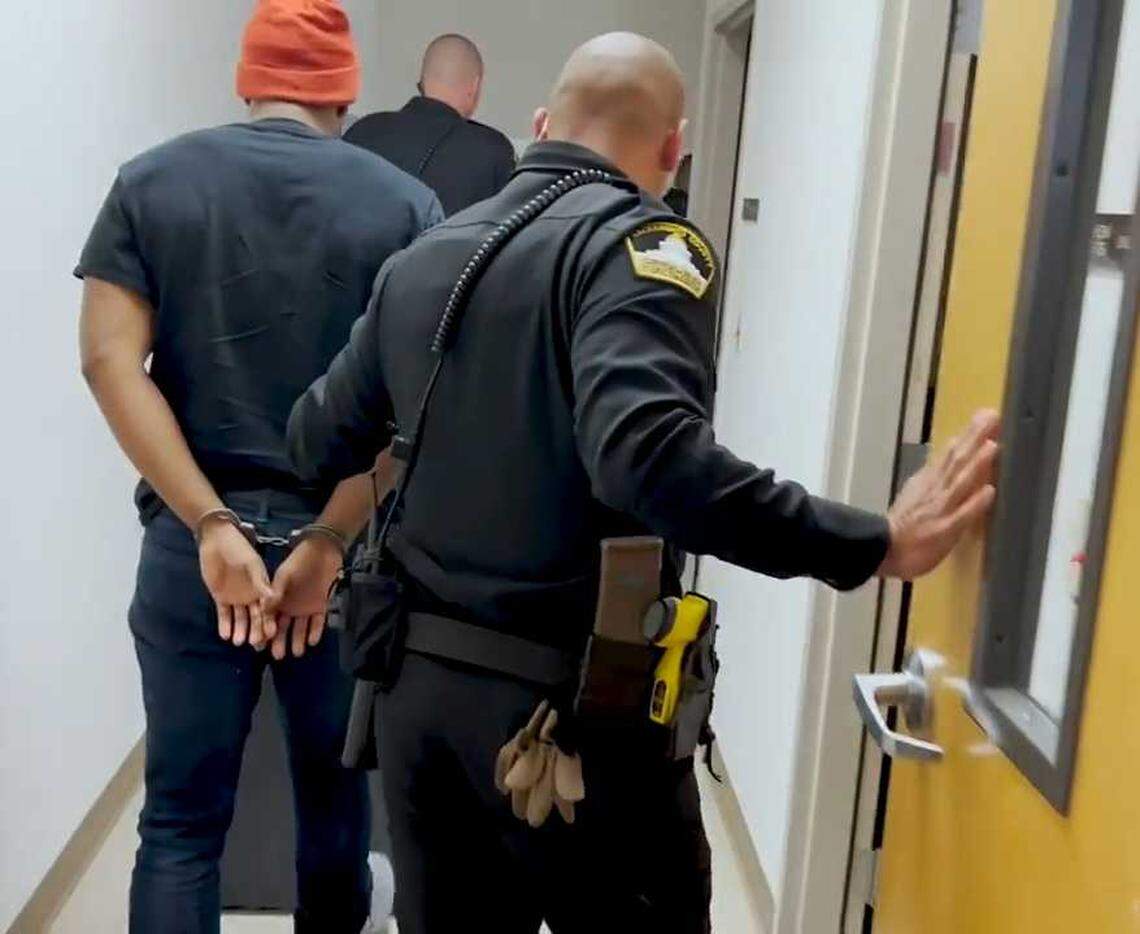 In a photo released by the Sacramento County Sheriff’s Office, Demetrius Davis is led away in handcuffs at a sheriff’s substation on Wednesday, April 26, 2022. Davis is suspected of using social media to lure over 80 children in U.S. into performing sex acts online.