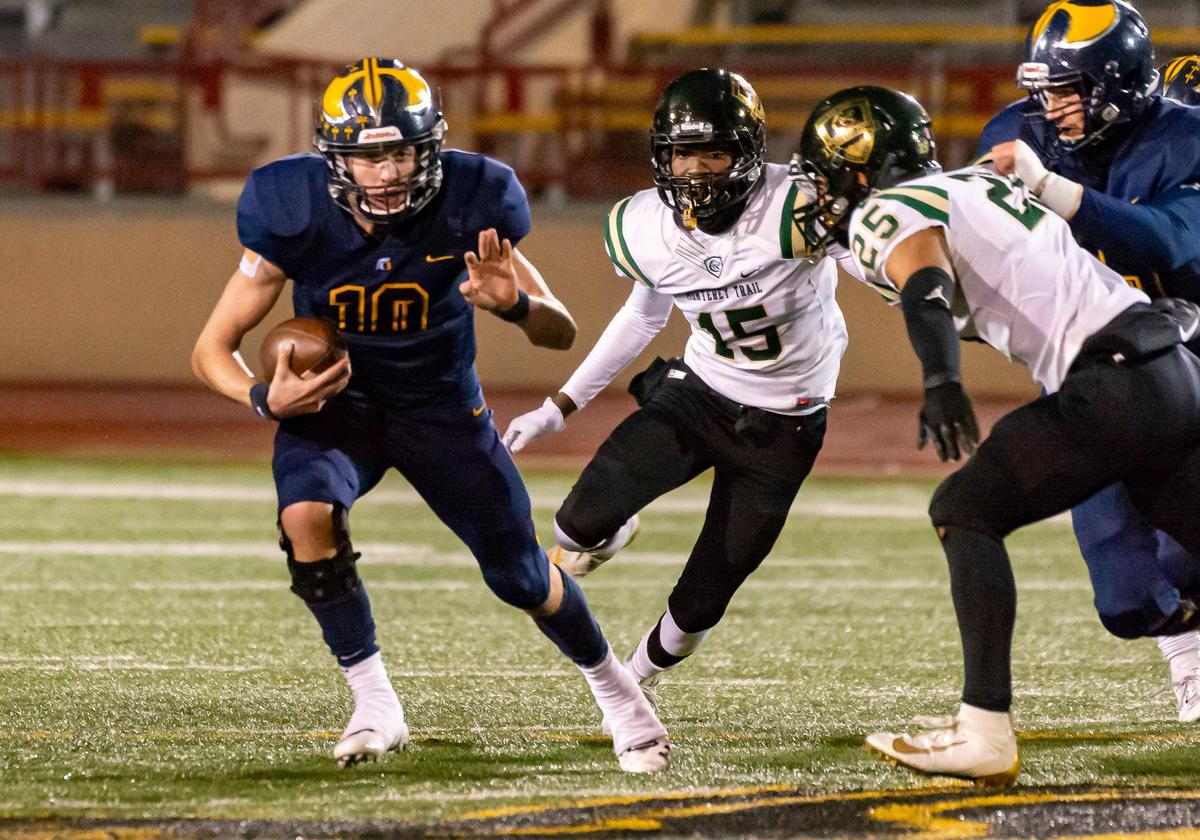 Oak Ridge Trojans quarterback Justin Lamson runs with the ball as the Trojans play the Monterey Trail Mustangs in the Sac-Joaquin Section Division I championship football game at Hughes Stadium in Sacramento, Saturday, Nov. 30, 2019.
