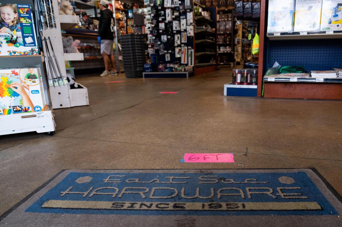 Pink strips of tape notify customers of the 6-foot spacing that’s become the norm in social distancing during the coronavirus era, as people search East Sac Hardware for home projects and repairs, Saturday, March 28, 2020.