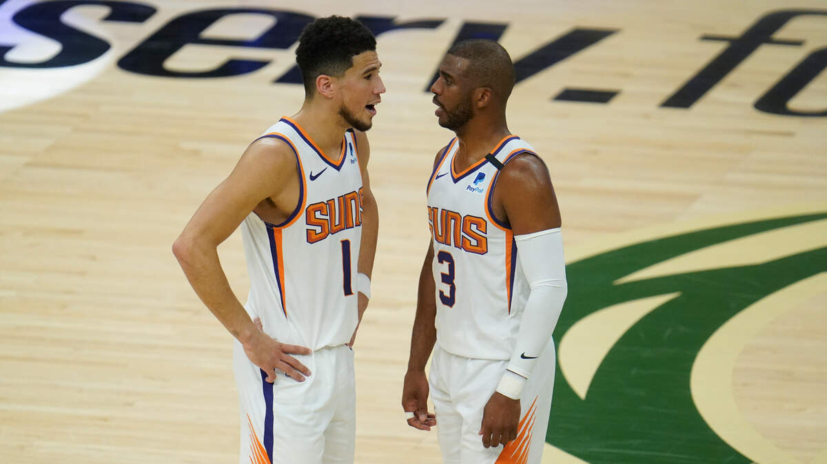 Phoenix Suns’ Chris Paul (3) talks with Devin Booker (1) during the first half of Game 3 of basketball’s NBA Finals against the Milwaukee Bucks, in Milwaukee, Sunday, July 11, 2021. (AP Photo/Paul Sancya)