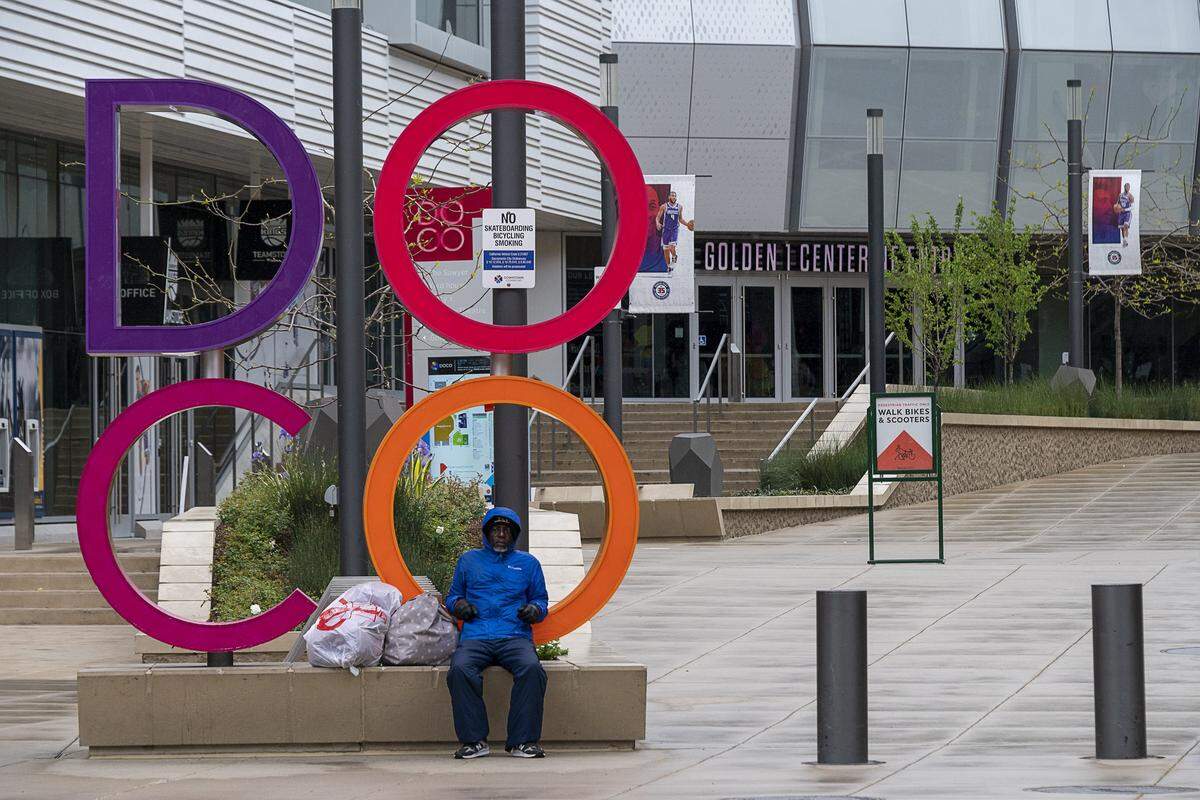 A lone person sits near the entry to DOCO that is empty of people during the coronavirus outbreak on Tuesday, March 24, 2020 in Sacramento.