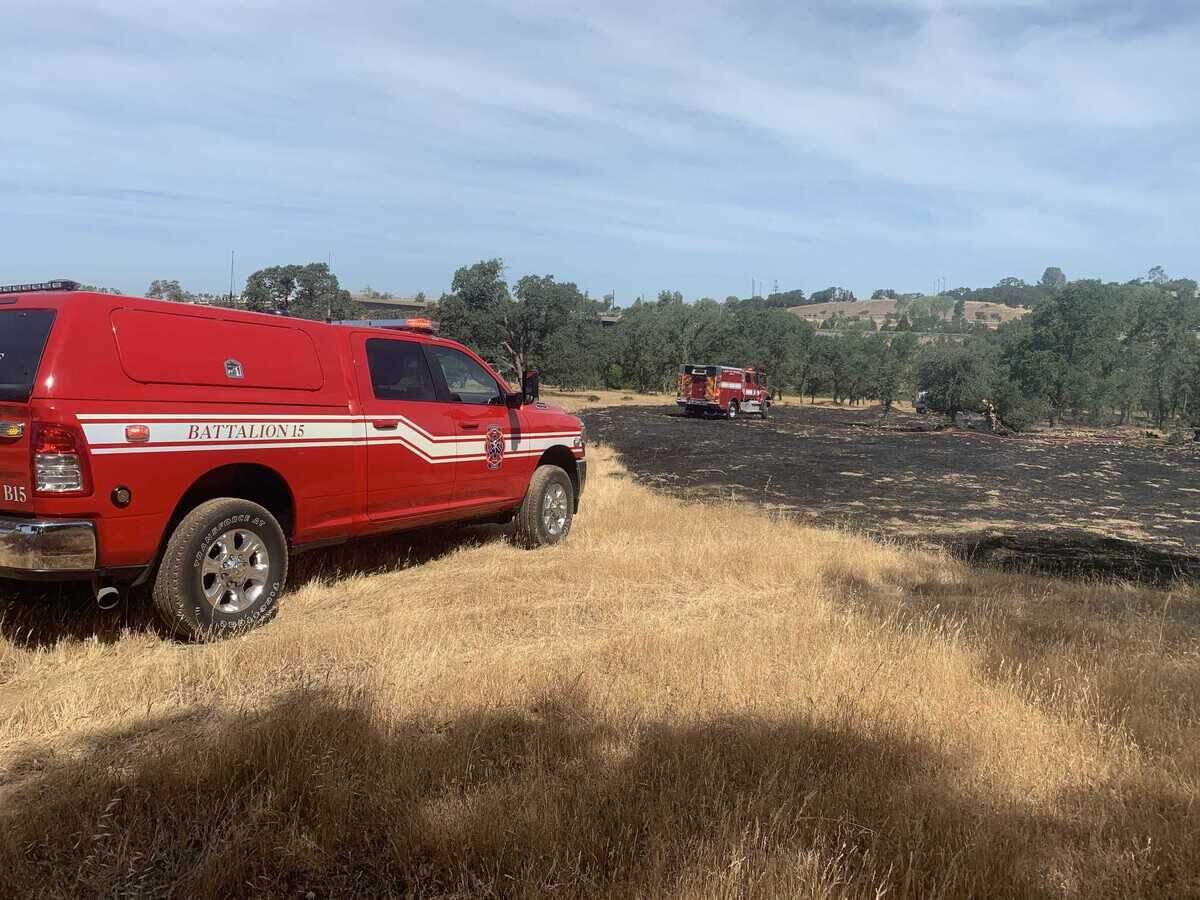 Firefighters mop up a small fire near Highway 50 and Prairie City Road in Folsom on Saturday, June 5, 2021.