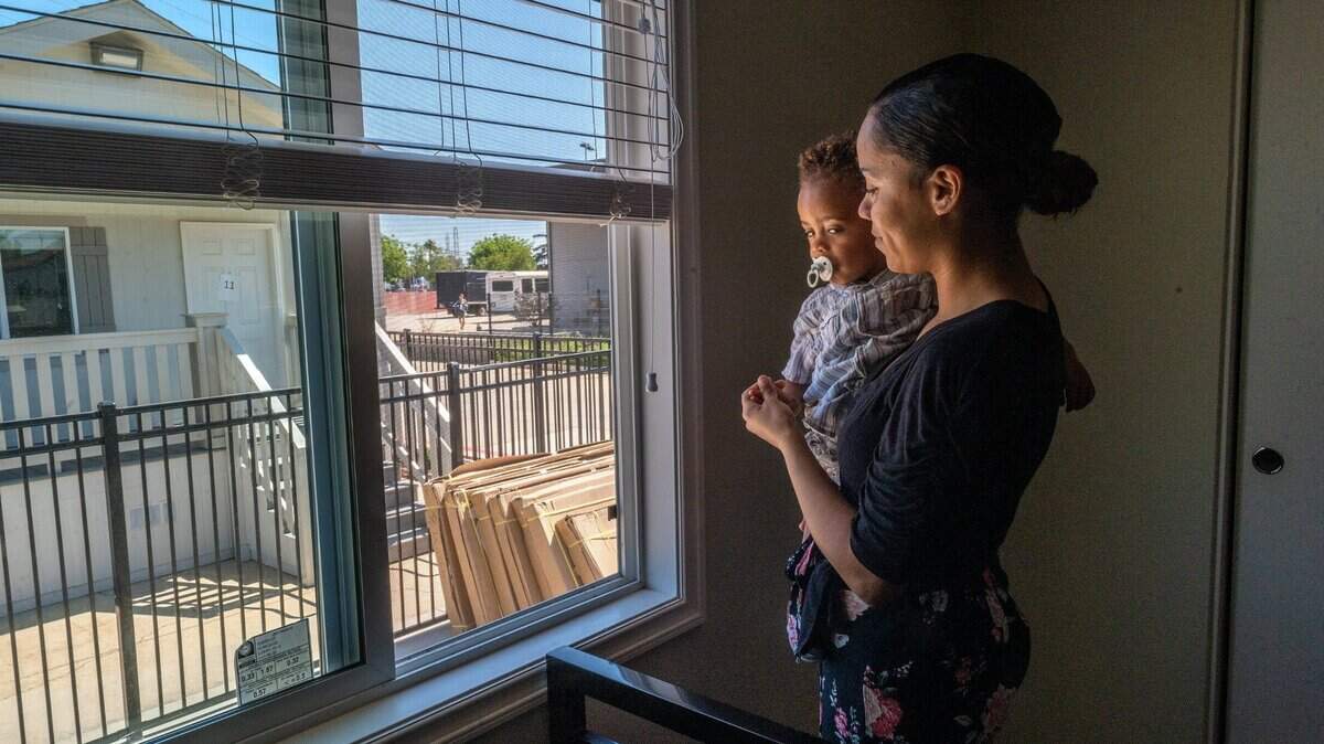 Marisol Garcia holds her son Ezura Turrell, 1, as she toured Saint John’s Square, one of the new affordable modular housing communities for homeless women and children on Wednesday July 14, 2021, in Sacramento.