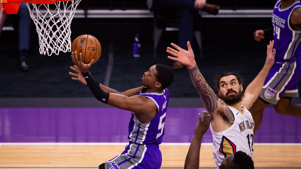Sacramento Kings guard De’Aaron Fox (5) drives past New Orleans Pelicans center Steven Adams (12), right, and New Orleans Pelicans forward Zion Williamson (1) to put up the first points of the NBA game Sunday, Jan. 17, 2021, at Golden 1 Center in Sacramento.