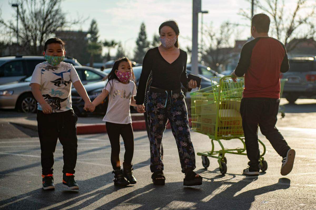 Mattew Lee, 9, Alexandra Lee, 8, and Martha Chang wear face masks out of concern of the coronavirus as they go grocery shopping at the SF Supermarket in south Sacramento on Friday, Jan. 31, 2020. Chang said she was having difficulty finding masks in the area due to the high demand in the Asian community. Here family was the first one to be photographed by The Bee while wearing masks because of the coronavirus pandemic.