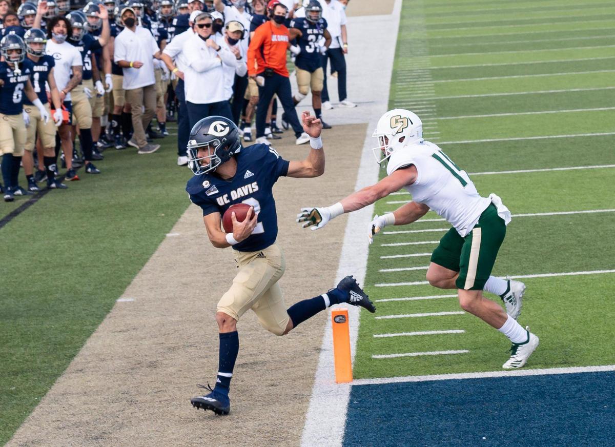 UC Davis’ Hunter Rodrigues runs in for a touchdown past Cal Poly’s Dawson Hurst during the second quarter of the Aggies’ first home football game of the spring season Saturday, March 20, 2021, in Davis.