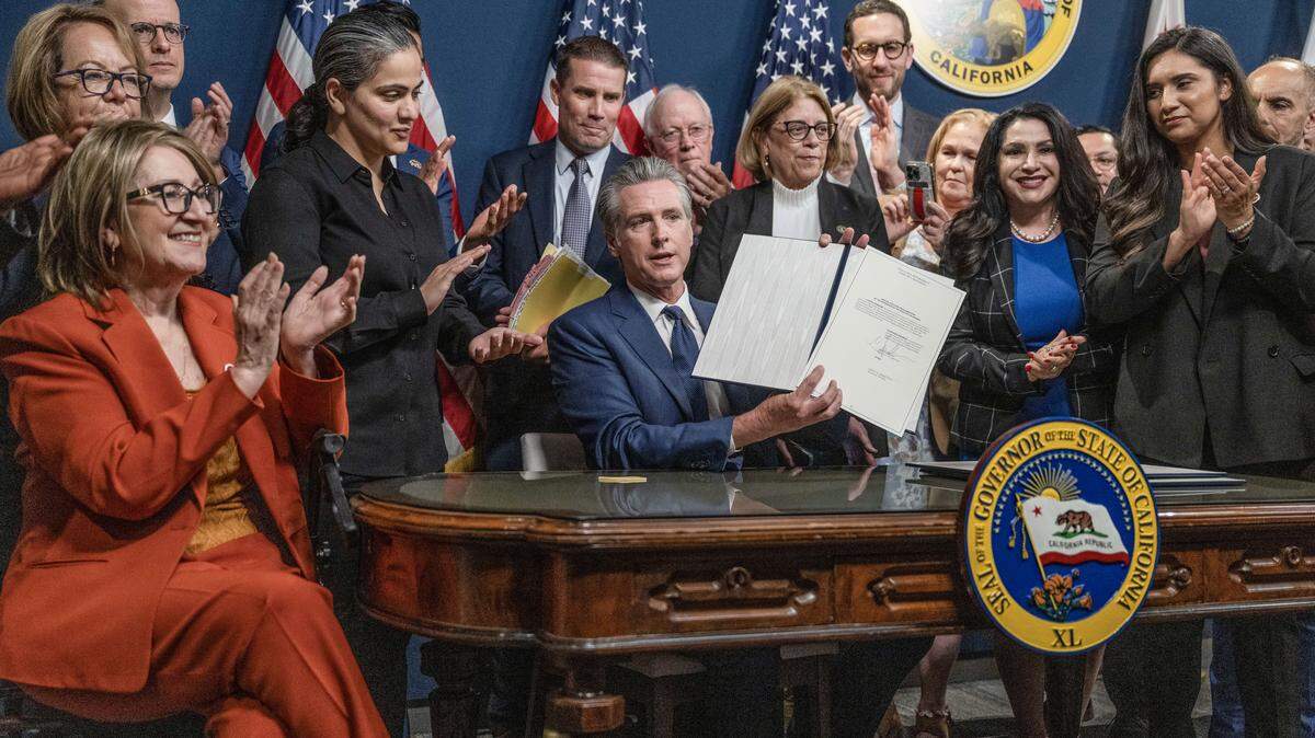 Gov. Gavin Newsom and California legislators celebrate after he signed the redistricting proposal bills on Thursday, Aug. 21, 2025, in Sacramento.