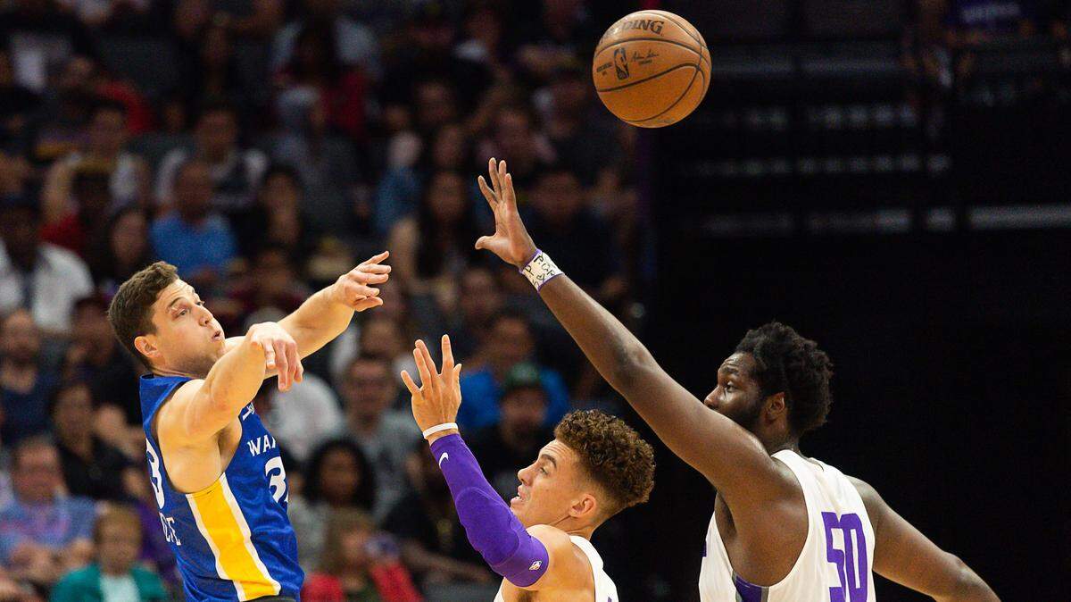 Golden State guard Jimmer Fredette passes over Sacramento’s Isaiah Pineiro, left, and Caleb Swanigan during the California Classic July 1.