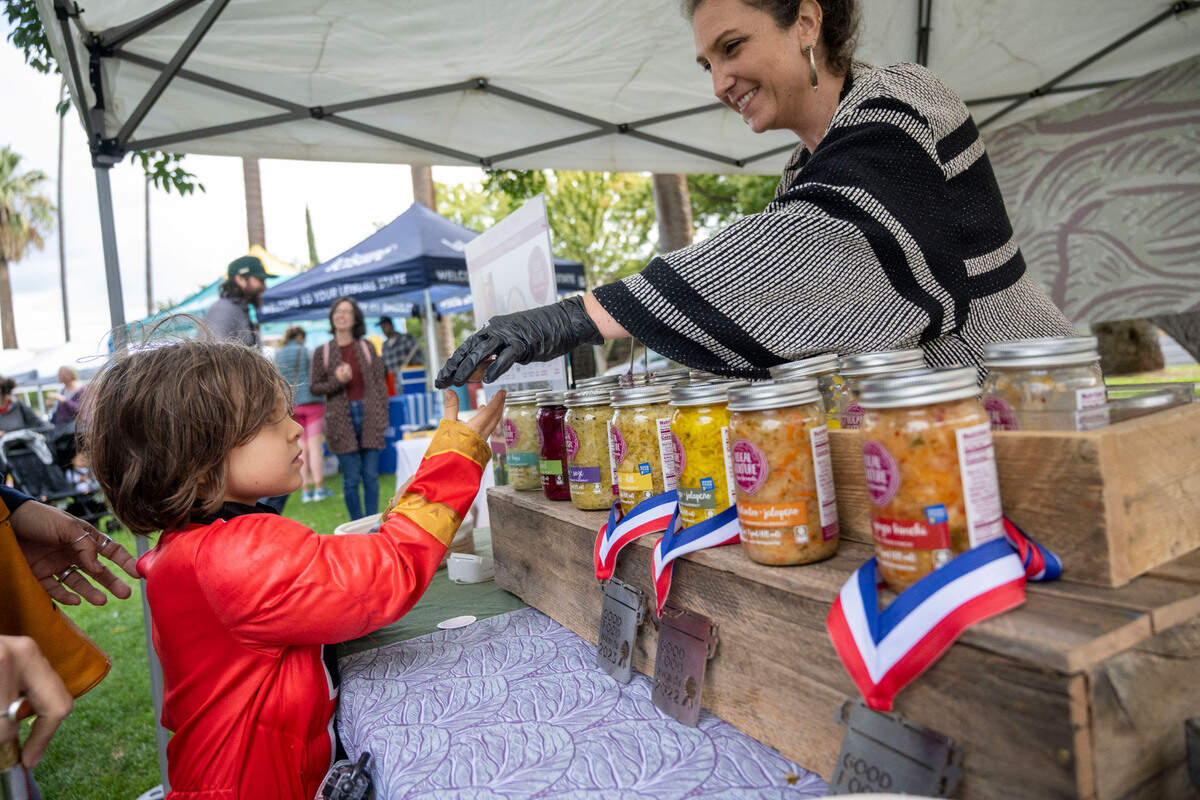 Dressed as a Power Ranger, Hugh Davis, 5, of Sacramento, gets a sample of fermented foods from Elissa Wolf Blank, co-owner of Local Culture of Grass Valley on Saturday during the 50th anniversary celebration of the Sacramento Natural Foods Co-op at Winn Park.