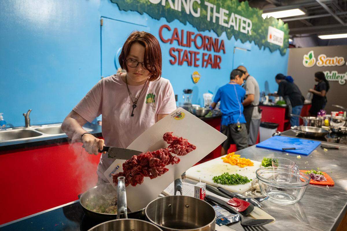 Cora Nixon, 14, of Marysville cooks carne asada during the California Junior Chef Cooking Challenge at the California State Fair on Tuesday, July 22, 2025, in Sacramento.