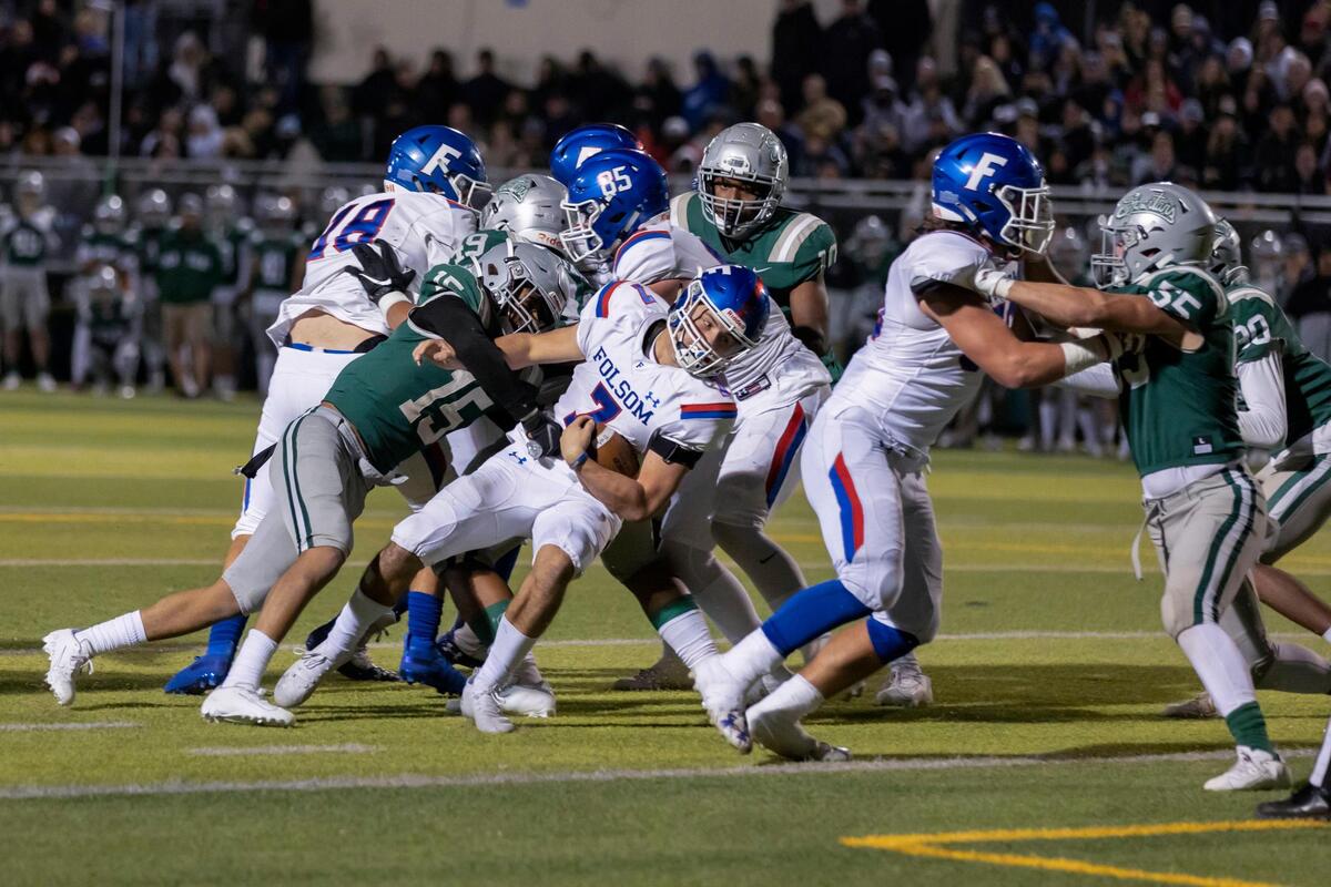 Folsom quarterback Tyler Tremain (7) scores a touchdown to take the lead during the fourth quarter of the CIF Division I regional finals game against De La Salle in Concord on Friday. The Bulldogs won 28-27.