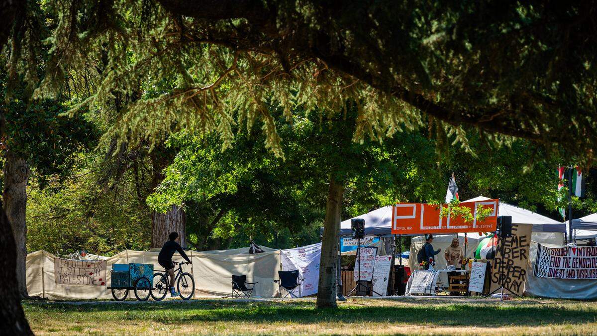 A cyclist enters the encampment of the Davis Popular University for the Liberation of Palestine, known as PULP, on the UC Davis quad Wednesday., the day the group announced its decampment at a press conference.