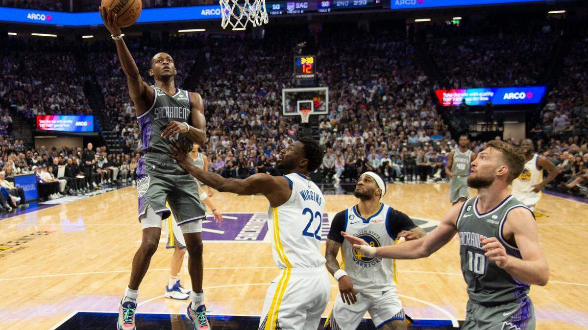 Sacramento Kings guard De’Aaron Fox (5) shoots over Golden State Warriors forward Andrew Wiggins (22) for a basket during Game 5 on Wednesday.