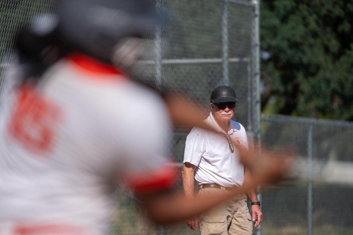 Roseville High’s Art Banks watches Malaya Johnson bat during a game against Woodcreek High School on Monday.