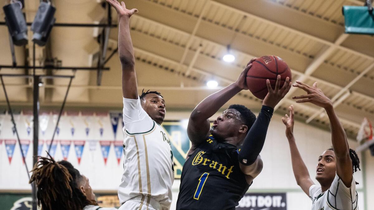 The Monterey Trail Mustangs’ Varick Lewis (0), left, blocks a shot by Grant Pacers guard Kiku Parker (1) on Wednesday at Monterey Trail High School in Elk Grove.