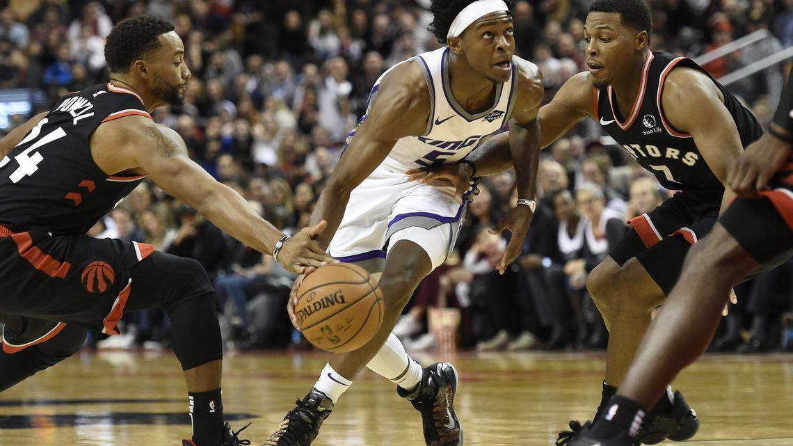 Sacramento guard De’Aaron Fox drives between Toronto guards Norman Powell, left, and Kyle Lowry on Wednesday night.