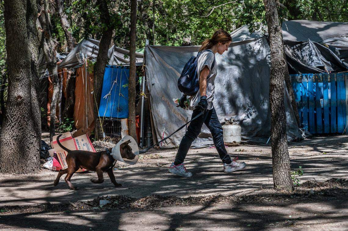 Rachelle Beck, 37, walks with her dog Bubba along the American River on Tuesday, June 8, 2021, in Sacramento.