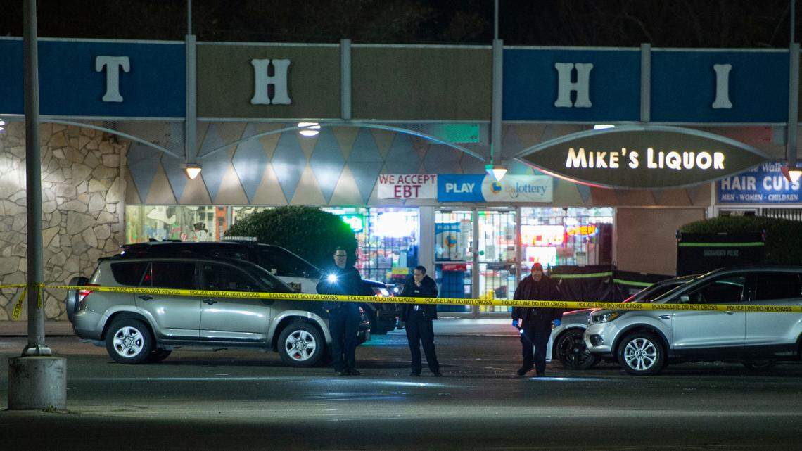 Sacramento Police search the parking lot with flashlights after a shooting at South Hills Shopping Center in South Land Park on Sunday, Jan. 2, 2022.