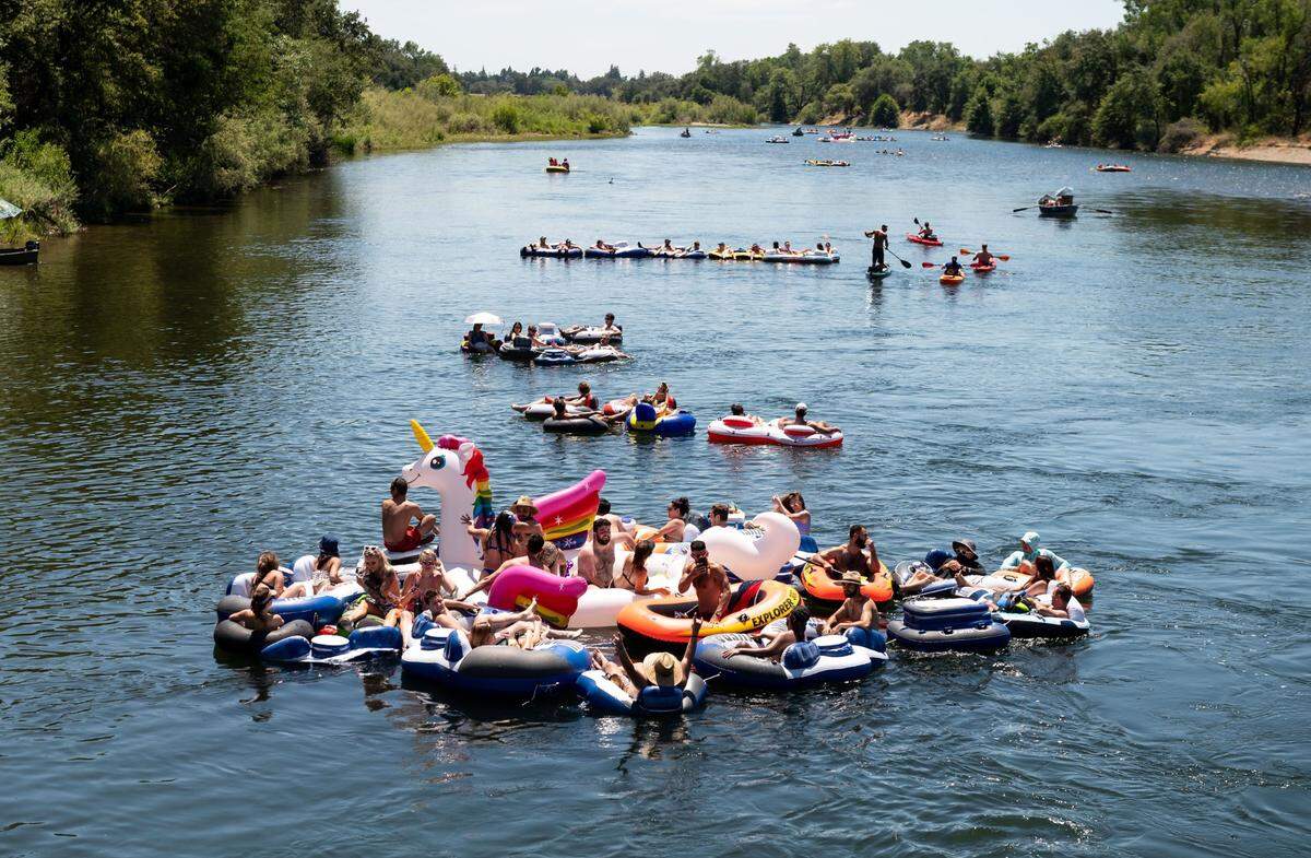 People float in the cool American River on a hot June 20, 2020, as seen from the Lower Sunrise Recreational Area in Sacramento County.