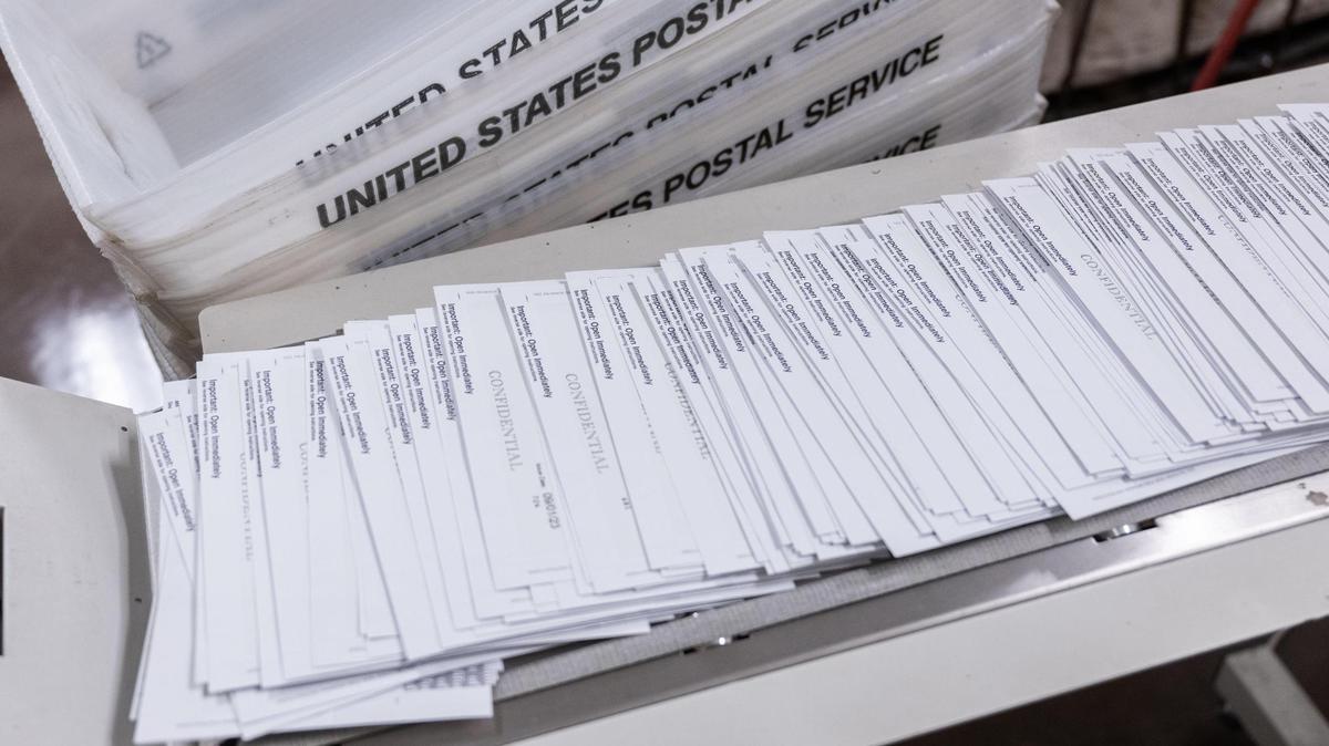 Sealed paychecks for California state workers are handled by a mail machine in August 2023.