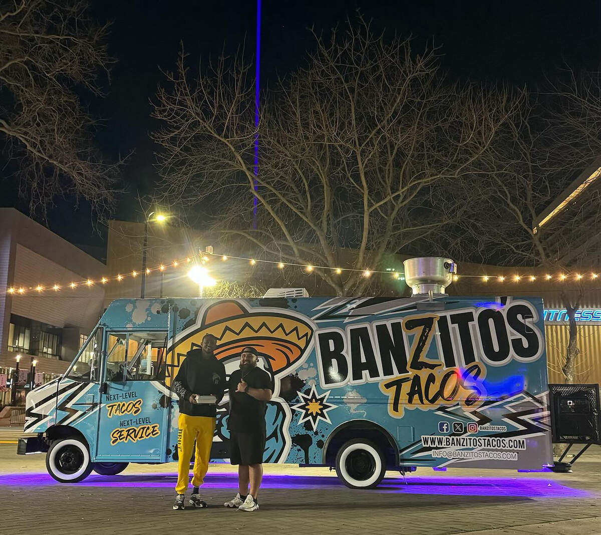 Banzito’s Tacos owner Adam Saldaña stands with the Sacramento Kings’ De’Aaron Fox as the beam shines above Sacramento.