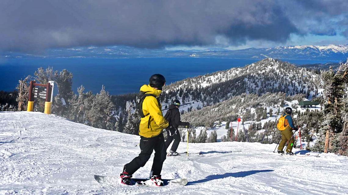 Above a crystal clear view of Lake Tahoe, a snowboarder explores fresh powder on Jan. 7, 2024, at Heavenly Ski Resort. 