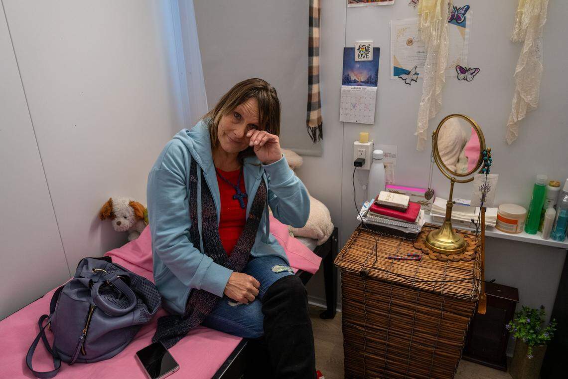 Sheleko Maynard, 55, dabs away a tear at Sacramento County’s Stockton Boulevard Safe Stay Community in December as she describes finding the strength to avoid relapse and discard her drug paraphernalia. She said she hopes to find housing in 2026, but she would welcome living in a senior micro-community proposed by the city of Sacramento if she could have overnight visitors, her own bathroom and the ability to cook for her family.