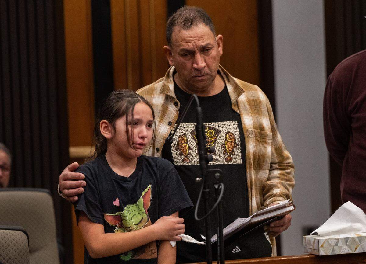 Eight-year-old Violet Rodriguez is comforted by her grandfather Juan Carlos Rodriguez Sr. as she holds back tears on Monday while asking for justice for her father Juan Carlos Rodriguez and uncle Lionel Rodriguez, who died after being hit by a police issued vehicle driven by Sacramento Police Detective Jonathan Thomas Nangle.
