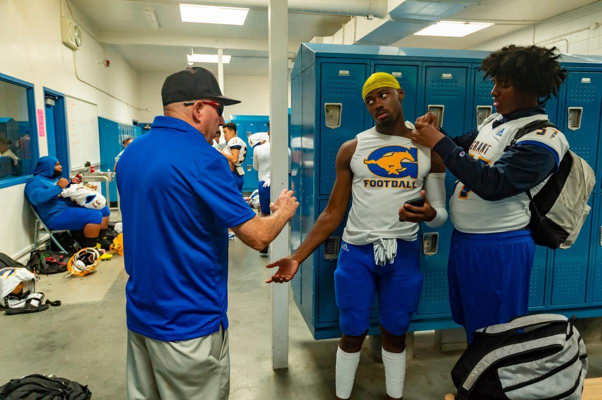 Grant High School Pacers head coach Mike Alberghini talks to his players before a game against the Davis High School Blue Devils in Davis, Friday, Aug 23, 2019.