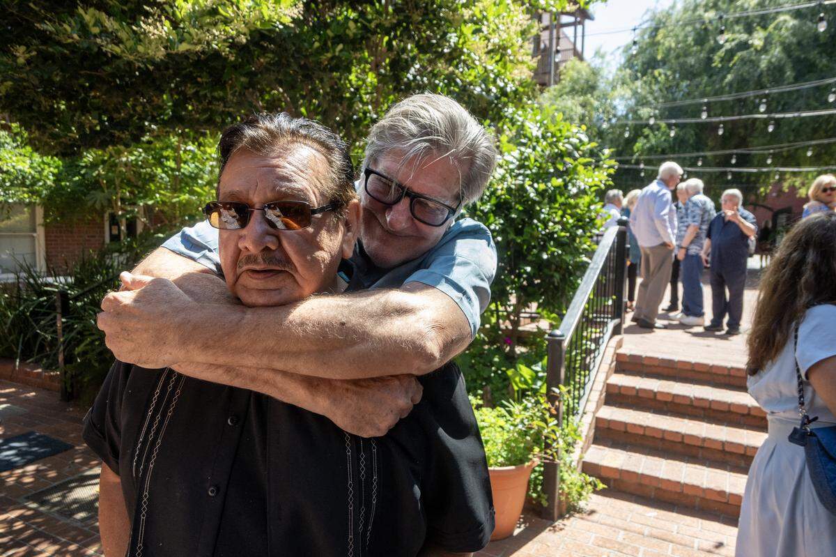 Retired reporter Mark Hedlund embraces retired news photographer Anthony Cisneros at the Dick Cable remembrance at The Invitation Room in Old Sacramento on Saturday.