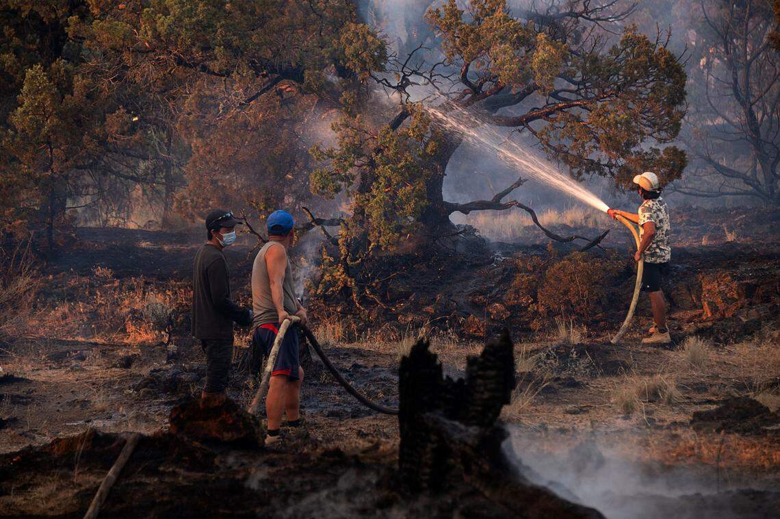 Hmong residents brought in their own water tank truck to help extinguish hot sports on a marijuana farm during the Lava Fire on Tuesday, June 29, 2021 outside of Weed in Siskiyou County. Siskiyou County sheriff said officers shot and killed a man after he fired a gun at them near a large complex of cannabis farms threatened by the Lava Fire.