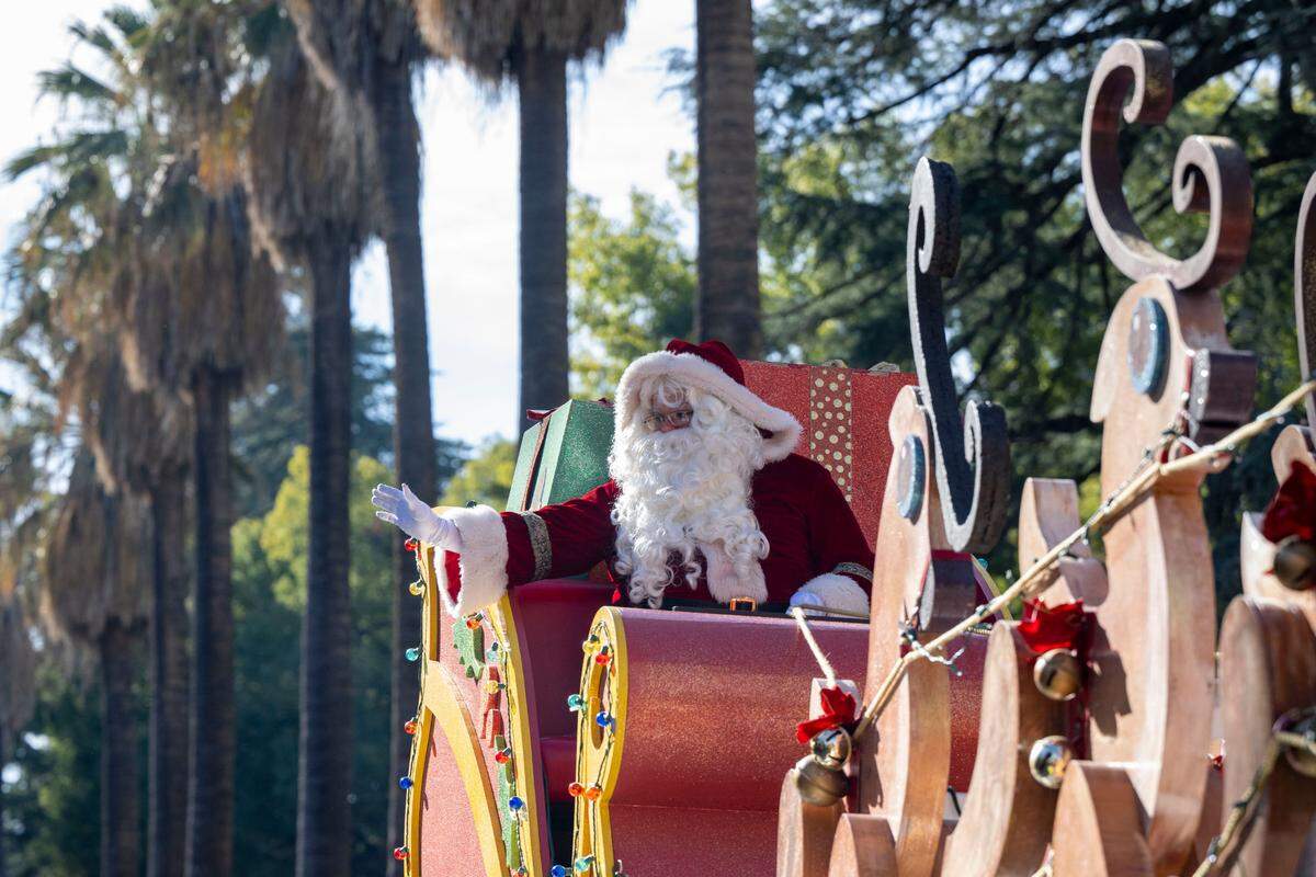 Santa rides in his sleigh pulled by reindeer on top of a Macy’s float at the 40th annual Sacramento Santa Parade around Capitol Park in 2023. 