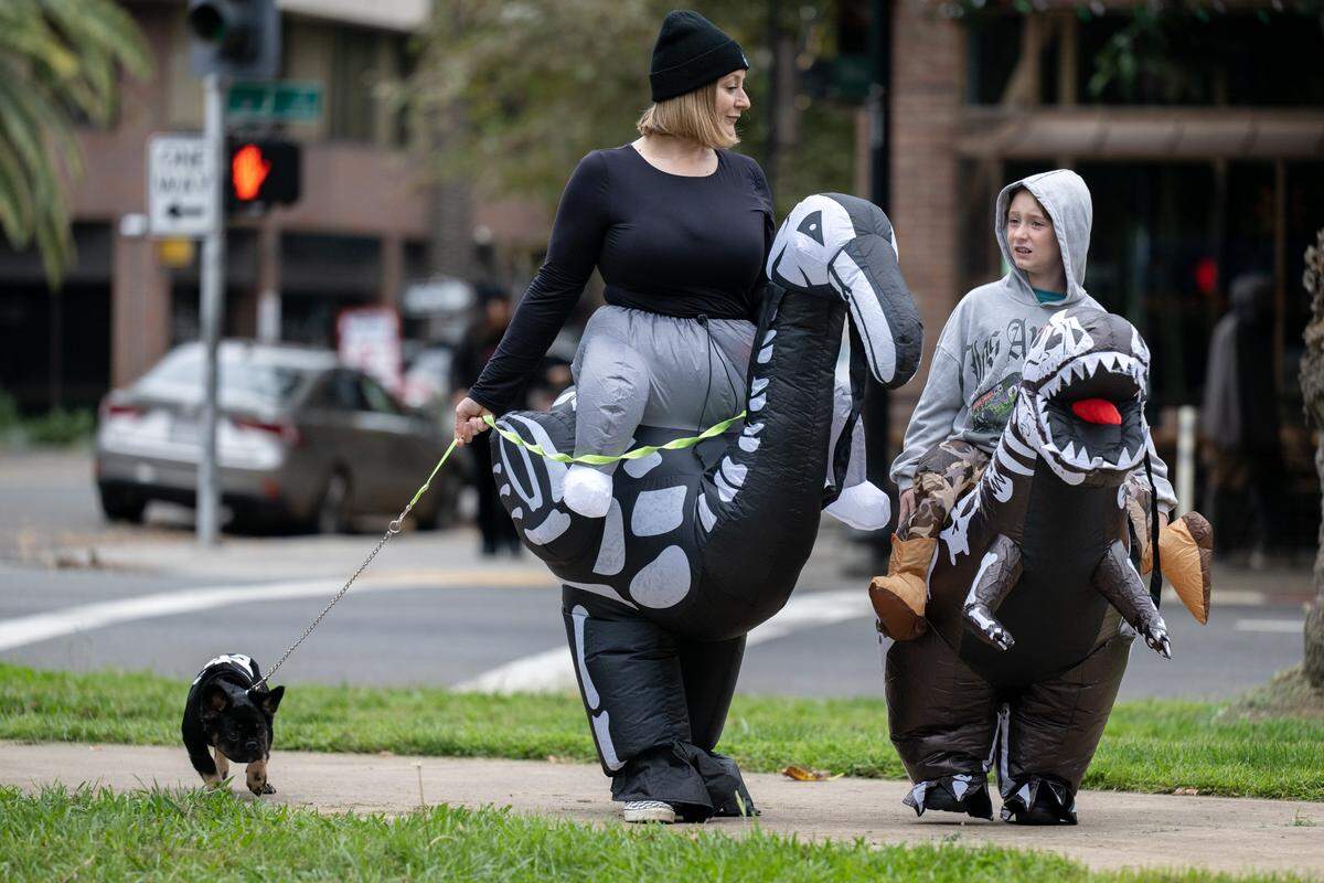 Bailey and Lucca Inderbitzin with their pet Moonshine attend the Midtown Halloween Festival & Pooch Parade at James Marshall Park on Saturday in Sacramento.