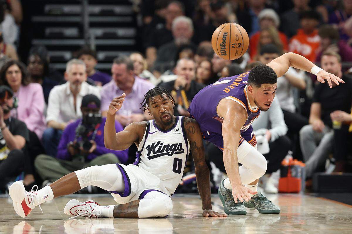Malik Monk of the Sacramento Kings collides with Devin Booker of ,the Phoenix Suns during the first half of the NBA game at Mortgage Matchup Center on October 22, 2025 in Phoenix, Arizona.