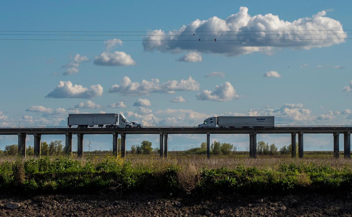 Two semi-trucks pass each other on Interstate 5 in Yolo County on Thursday, March 26, 2020. Commercial freight truckers are considered an essential industry during the coronavirus crisis. The federal government has deregulated hours for truckers delivering medical supplies, groceries, and key consumer items.