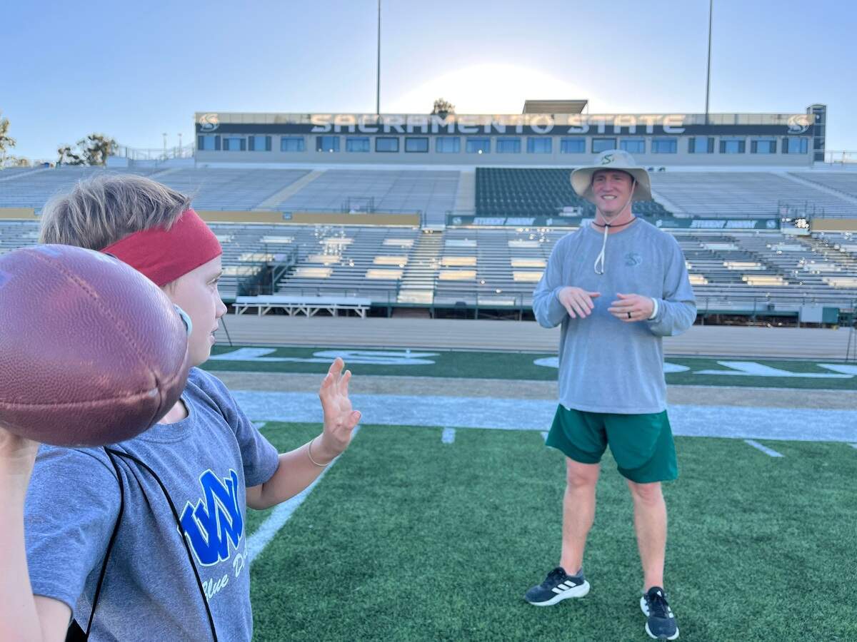 Sacramento State football coach Andy Thompson delights in playing catch with his sons, Austin, left, and Teague.